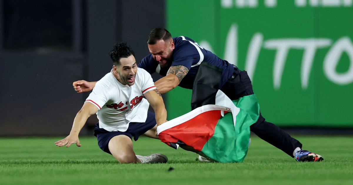 A fan carrying a Palestinian flag runs onto the field at 9:11 p.m. in the middle of the seventh inning at Yankee Stadium on Sept. 11, 2026, in the Bronx borough of New York City.