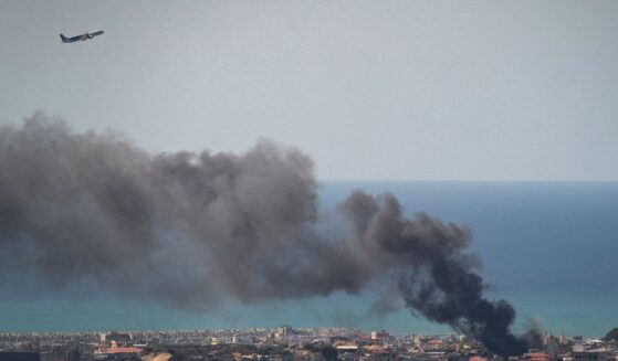 A MEA commercial airplane is flying above the smoke after an IDF airstrike on March 17, 2026, in Beirut, Lebanon.