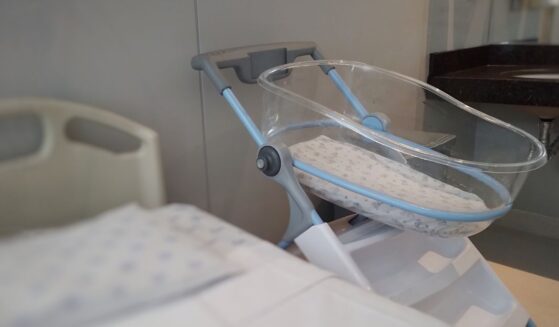 An acrylic crib for a newborn in a maternity room.