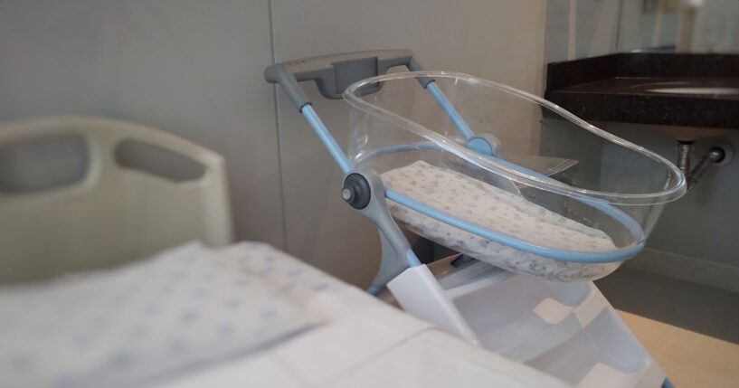 An acrylic crib for a newborn in a maternity room.