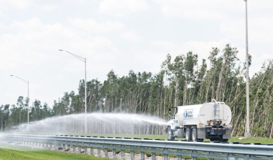 A truck spraying water on a highway near Miami, Florida, on April 30, 2018.