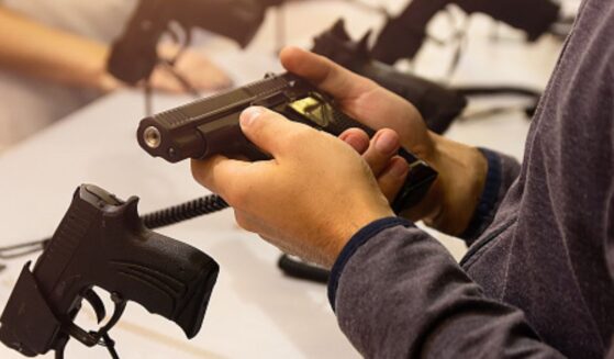 A gun is held by an instructor.