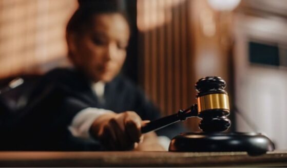 A Judge slams a gavel on a wooden block.