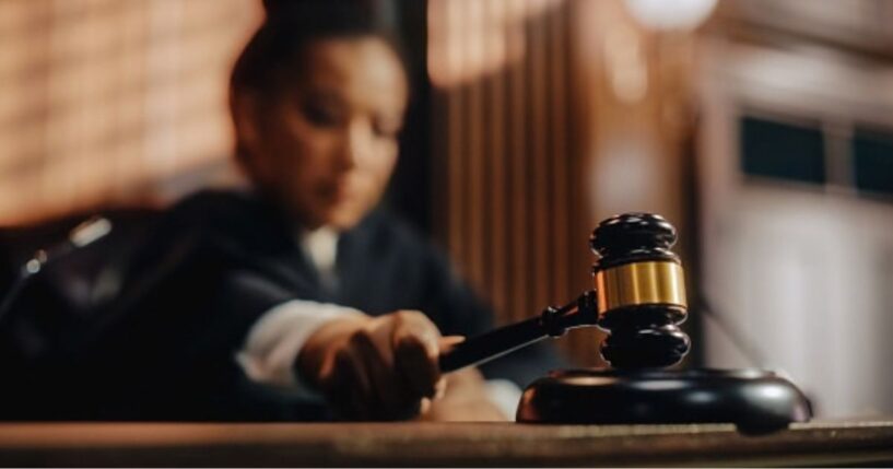 A Judge slams a gavel on a wooden block.