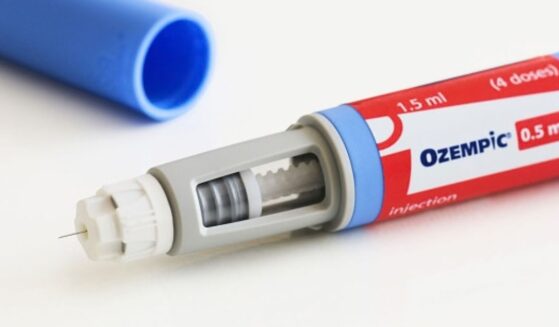 An Ozempic pen is pictured on a white table.