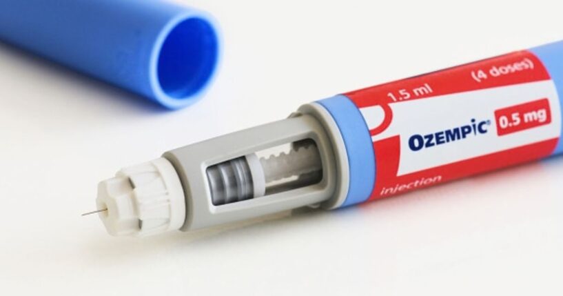 An Ozempic pen is pictured on a white table.