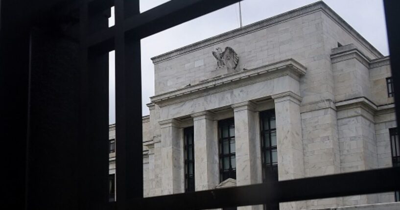 The Federal Reserve building stands under gray skies in Washington, D.C. behind a gate on June 17, 2020.