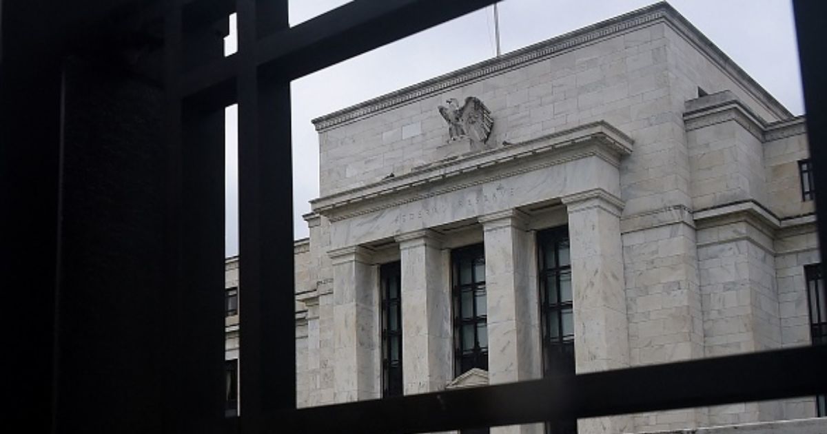 The Federal Reserve building stands under gray skies in Washington, D.C. behind a gate on June 17, 2020.