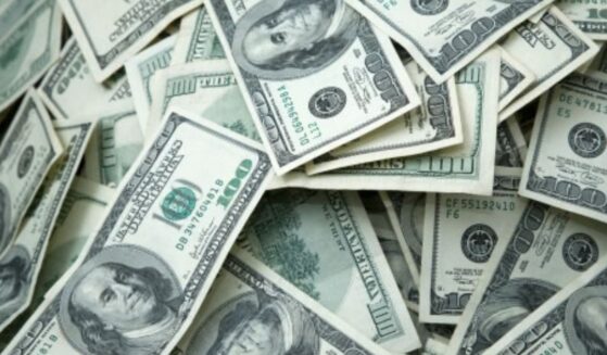 Hundred dollar bills lay across a table.