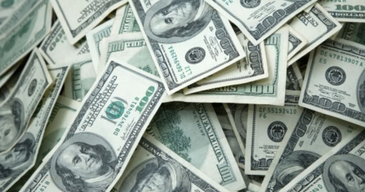 Hundred dollar bills lay across a table.