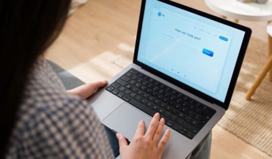 A woman types on her computer to an AI chat bot.