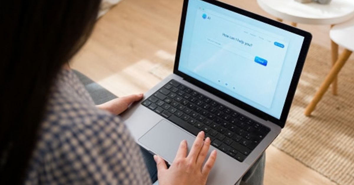 A woman types on her computer to an AI chat bot.