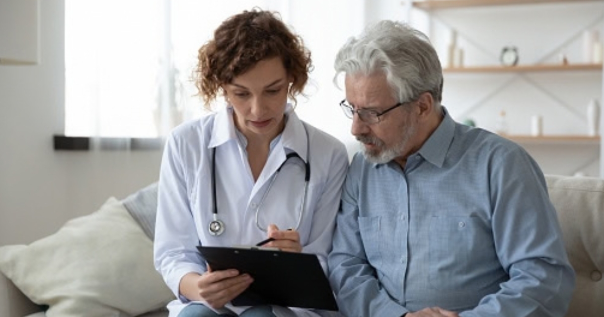 A doctor going over information on a clipboard with their patient.