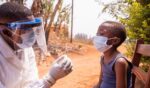 A young child in Africa is given a shot for Ebola.