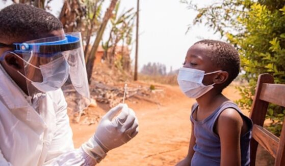 A young child in Africa is given a shot for Ebola.