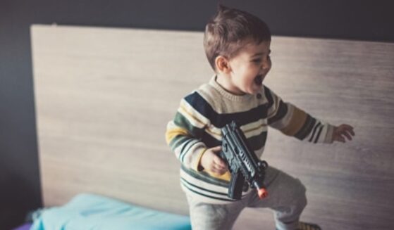 A kid plays with a BB gun.