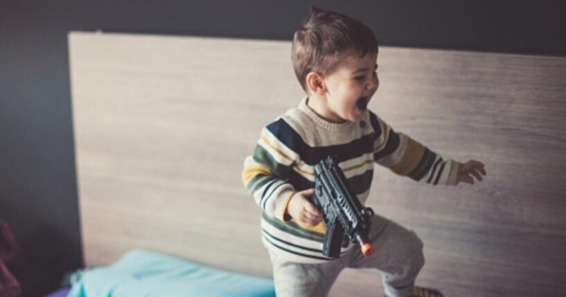 A kid plays with a BB gun.