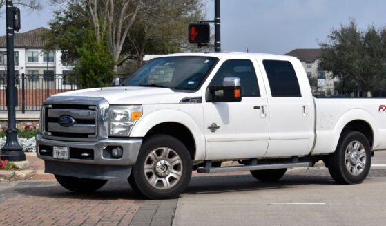 A white 2013 Ford F-250 Super Duty truck sits in the road in Houston, Texas.