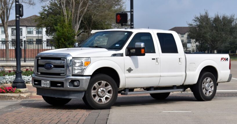 A white 2013 Ford F-250 Super Duty truck sits in the road in Houston, Texas.