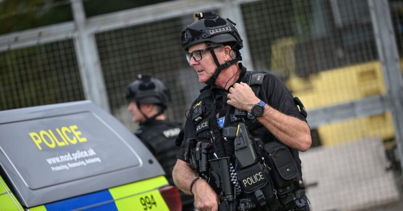 An armed police man mans a roadblock at the entrance to the RAF Fairford air base in England during a counter-terrorism investigation on Sept. 27, 2026.