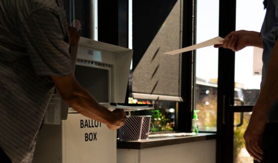 A voter drops a ballot into a ballot box at the Minneapolis Elections & Voter Services building on Sept. 20, 2024. in Minneapolis, Minnesota. The Department of Justice indicted 10 people accused of voting illegally in 2022, 2024, and 2026.