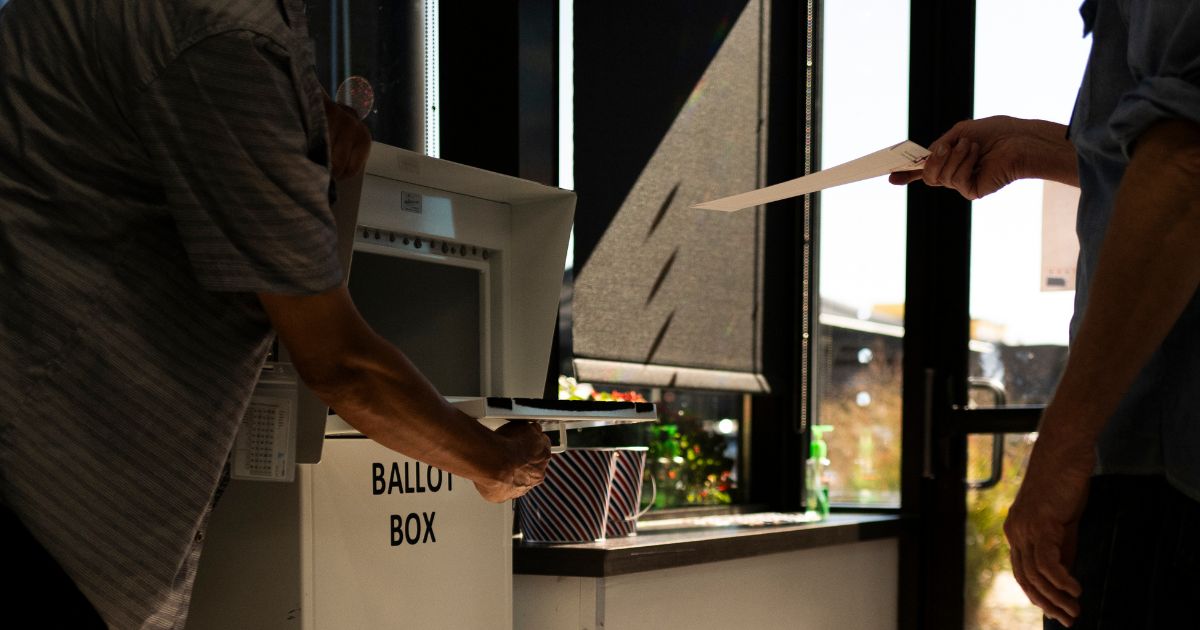 A voter drops a ballot into a ballot box at the Minneapolis Elections & Voter Services building on Sept. 20, 2024. in Minneapolis, Minnesota. The Department of Justice indicted 10 people accused of voting illegally in 2022, 2024, and 2026.