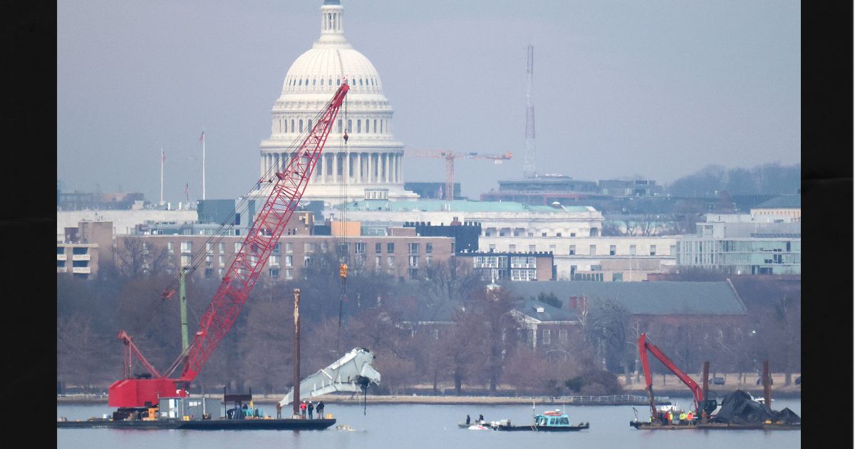 A crane lifts a piece of American Airlines flight 5342 from the Potomac River during recovery efforts on Feb. 3, 2025, in Arlington, Virginia. An American Airlines flight from Wichita, Kansas collided midair with a military Black Hawk helicopter while on approach to Ronald Reagan Washington National Airport outside of Washington, D.C., on Jan. 29, 2025 .