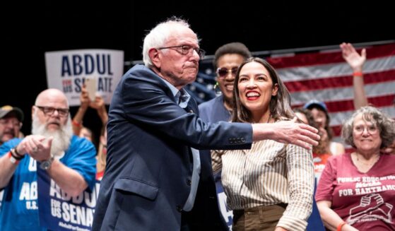 Sen. Bernie Sanders greets Rep. Alexandria Ocasio-Cortez at The People v. The Powerful rally at the Detroit Opera House on July 18, 2026, in Detroit, Michigan.