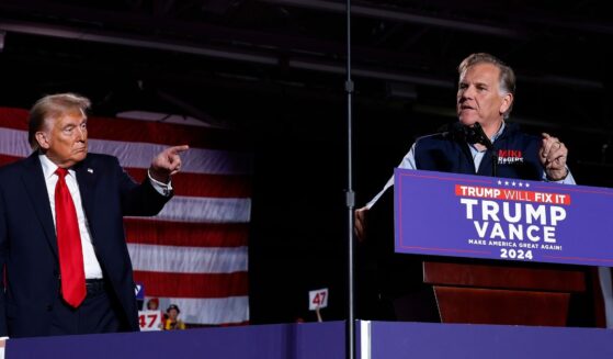 Republican Senate candidate Mike Rogers joins President Donald Trump on stage during a campaign rally at Macomb Community College on Nov. 1, 2024, in Warren, Michigan.