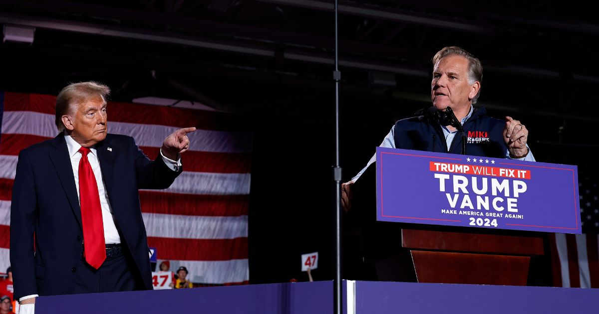 Republican Senate candidate Mike Rogers joins President Donald Trump on stage during a campaign rally at Macomb Community College on Nov. 1, 2024, in Warren, Michigan.