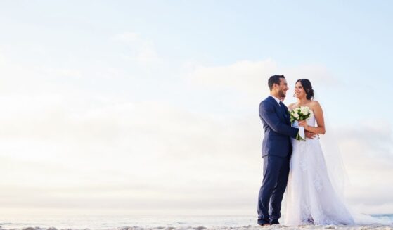 A young couple on the beach on their wedding day.