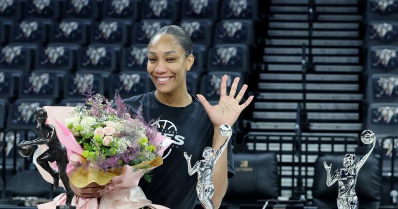 A'ja Wilson of the Las Vegas Aces poses while holding a bouquet of flowers after receiving the 2026 WNBA MVP award, her third consecutive and fifth career trophy, after a team walkthrough at Michelob ULTRA Arena on Oct. 8, 2026, in Las Vegas, Nevada.