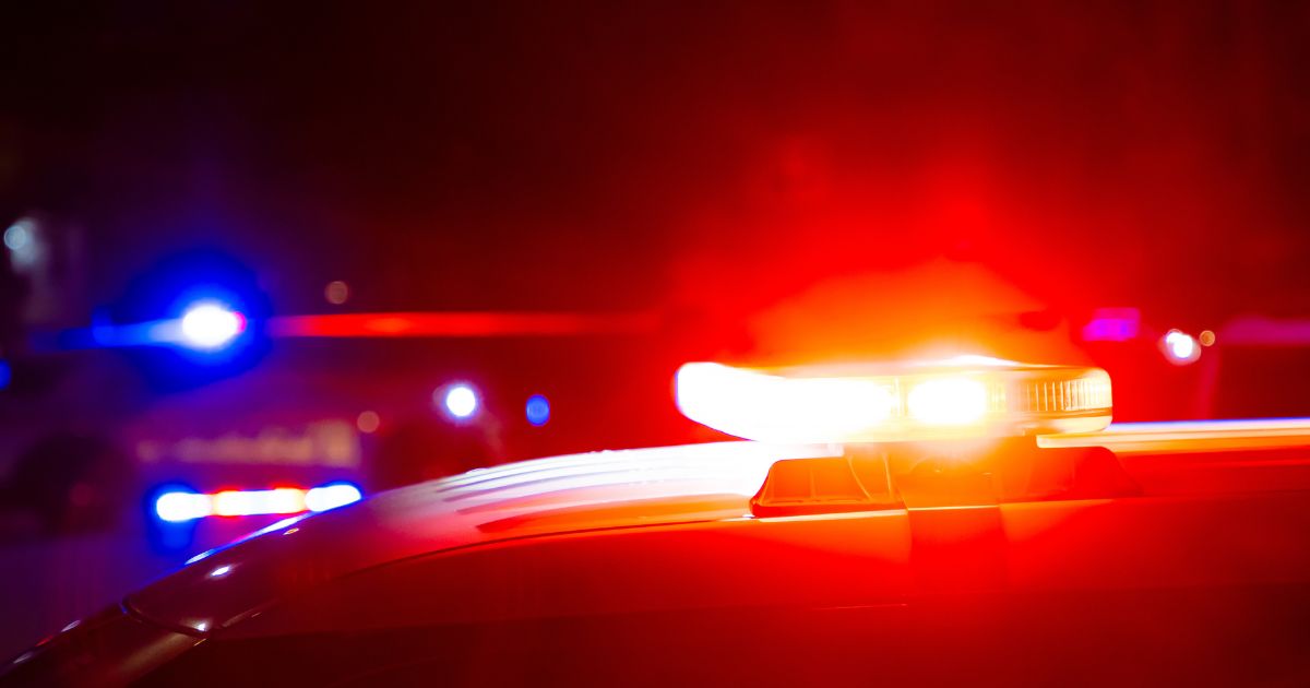 Red and blue police lights on a car at a crime scene at night with copy space.
