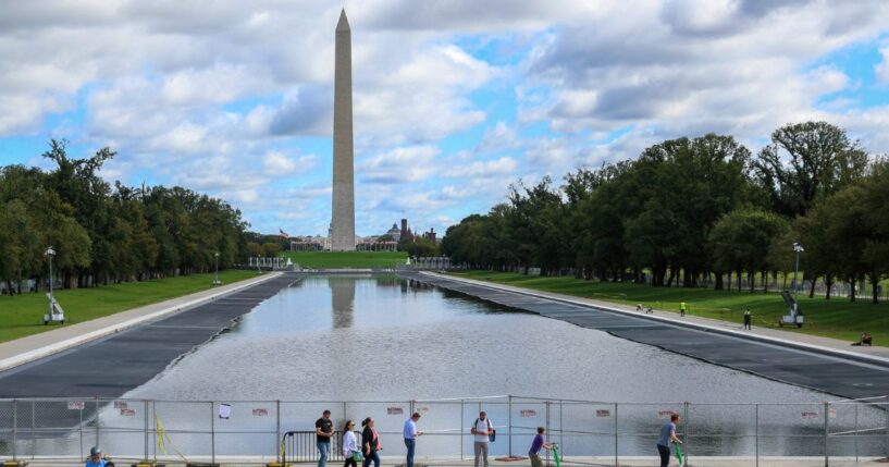 Visitors walk past the reflecting pool as it is refilled on Monday, Oct. 12, 2026.