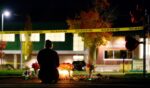 A woman grieves at a candlelight memorial out front of Silver Rail Elementary School on Oct. 15, 2026, in Bend, Oregon.