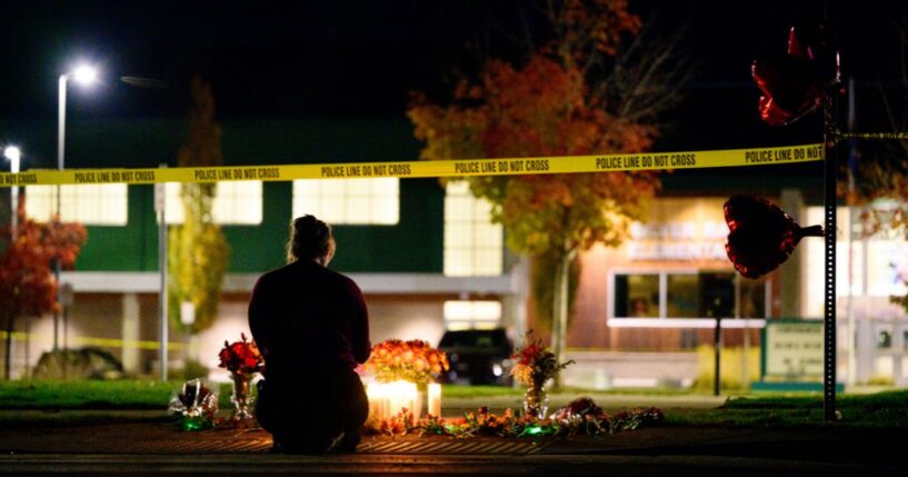 A woman grieves at a candlelight memorial out front of Silver Rail Elementary School on Oct. 15, 2026, in Bend, Oregon.
