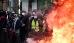 Protesters stand behind a fire during clashes prior to the start of a demonstration to protest against the "high cost of living" in Marseille, southern France, on Oct. 17, 2026.