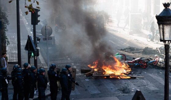 Police officers stand near a fire during an unauthorized demonstration marked by riots and clashes with law enforcement at Place de la Republique in Paris, Ile-de-France, France, on Oct. 18, 2026.