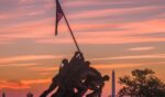 Sunrise turns the sky orange and red behind the U.S. Marine Corps War Memorial on Oct. 2, 2026, in Arlington, Virginia.