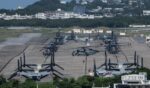 Helicopters and V-22 Ospreys are seen parked on the tarmac near buildings at Marine Corps Air Station Futenma in Ginowan, Okinawa prefecture, on Oct. 9, 2026.