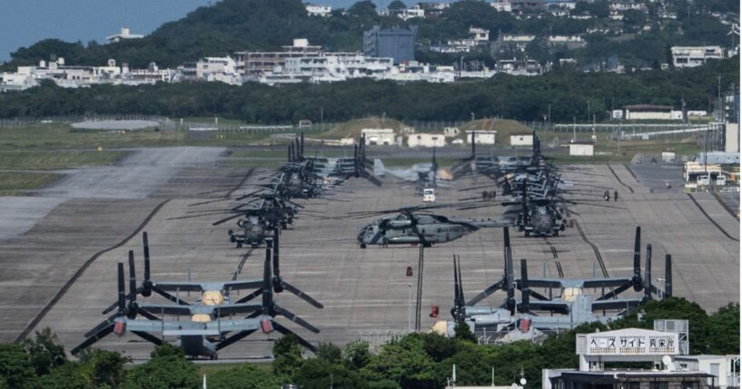 Helicopters and V-22 Ospreys are seen parked on the tarmac near buildings at Marine Corps Air Station Futenma in Ginowan, Okinawa prefecture, on Oct. 9, 2026.