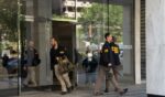 FBI agents leave the office of John Bolton, former national security adviser to President Trump, with several boxes and other materials on Aug. 22, 2025, in Washington, D.C.