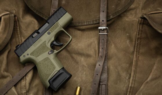 A pistol lays on a dark brown fabric.