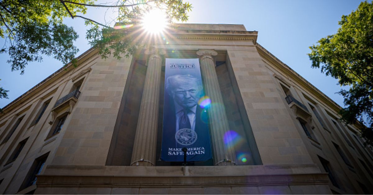 President Trump is displayed on a banner hanging between pillars at the Department of Justice headquarters in Washington, D.C. on May 18, 2026.