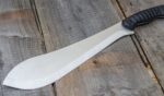 A machete is pictured on a wooden table.