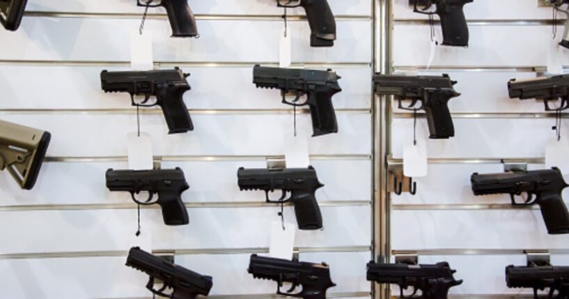 A gun rack is viewed on a wall.