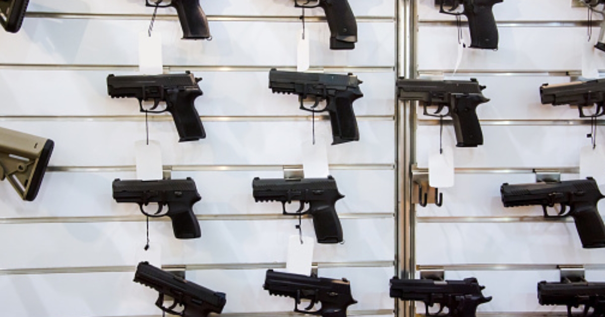 A gun rack is viewed on a wall.