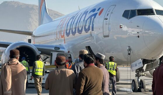 People stand on a tarmac next to a Flydubai airline after it landed in Kabul International Airport in Kabul on Nov. 15, 2023.
