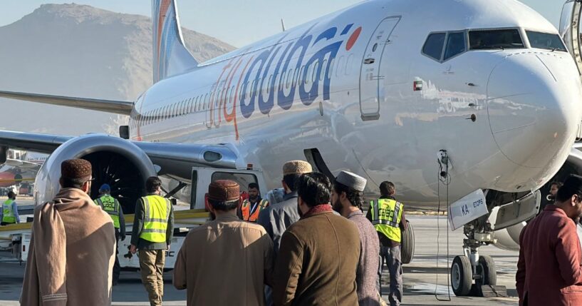 People stand on a tarmac next to a Flydubai airline after it landed in Kabul International Airport in Kabul on Nov. 15, 2023.