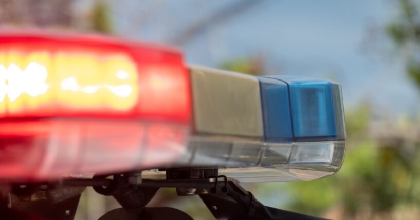 Emergency lights flash on top of a police car.